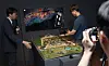 Yu Jeong-min, an associate professor at the Korea National University of Cultural Heritage, left, demonstrates an augmented reality game as part of the National Palace Museum of Korea's latest exhibition, “Hwaseong Reimagined: A Digital Dive into an 8-Day Royal Procession,″ in central Seoul on Tuesday. [NEWS1]