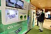 Environment Minister Han Jeoung-ae puts a plastic bottle into a crusher machine in Blackyak's Yangjae branch in Seocho District, southern Seoul, on Wednesday. The plastic bottle and T-shirt exchange event shows how plastic bottles can be recycled. [YONHAP]