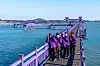 Purple Island's elderly residents, dressed in purple, greet the island's visitors on Purple Bridge. [BAEK JONG-HYUN]