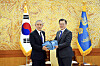 President Moon Jae-in, right, presents outgoing U.S. Ambassador to Korea Harry Harris with a farewell gift of Andong soju at the Blue House in central Seoul Tuesday. [BLUE HOUSE]