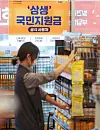 A sign posted at a convenience store in Seoul on Sunday notifies customers that it is accepting emergency relief grant payments until the end of this year. The government's 250,000 won ($210) emergency relief grant application starts Monday. [YONHAP]