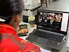 An instructor talks with STAY. G members participating in the center's social dining program via Zoom. [STAY. G]