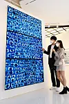 Models look at a work by the late Kim Whan-ki through LG Electronics' high-definition LED signage screens at Lotte Department Store's World Tower branch in southern Seoul on Monday. [LG ELECTRONICS]