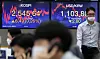 An employee wearing a face mask walks in front of two screens showing the Kospi index at a dealing room in Hana Bank in Jung District, central Seoul, on Wednesday. The Kospi hit a new record, closing at 2,545.64 points, up 0.26 percent, or 6.49 points, as investors turn optimistic. The total net profit from the 590 companies listed on the main bourse increased by 81.31 percent in the third quarter, according to data from the Korea Exchange on Wednesday. [YONHAP]
