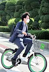 People Power Party Chairman Lee Jun-seok rides a city rental bicycle, commongly known as a ddareungi, on his commute to the National Assembly on Sunday. [OH JONG-TAEK]