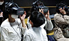 A child looks at his mother as she tries out a virtual reality (VR) interview at a job expo for foreigners married to Koreans, held at the Seoul Citizens Hall in Jung District, central Seoul, on Wednesday. A total of 19 companies participated in the job fair and conducted one-on-one interviews to recruit workers on site. Information on job openings of around 30 companies was also provided to those who came to the job fair. [YONHAP]