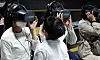 A child looks at his mother as she tries out a virtual reality (VR) interview at a job expo for foreigners married to Koreans, held at the Seoul Citizens Hall in Jung District, central Seoul, on Wednesday. A total of 19 companies participated in the job fair and conducted one-on-one interviews to recruit workers on site. Information on job openings of around 30 companies was also provided to those who came to the job fair. [YONHAP]