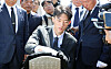 Chun Woo-won, grandson of the late military dictator and former President Chun Doo Hwan, wipes a gravestone belonging to a victim of the May 18 Gwangju Uprising with his coat on Friday at the May 18th National Cemetery in Gwangju. [YONHAP]