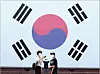 People take a photo in front of a large Korean flag at Seodaemun Prison History Hall in western Seoul, ahead of this year’s Liberation Day on Aug. 15. [YONHAP]