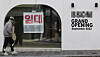 A pedestrian in Seoul on Feb. 25 walks past a vacant retail property, which previously contained a store that opened in September 2022 but closed only three years later. [YONHAP]