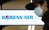A masked passenger passes by in front of the Korean Air check-in counter at Gimpo International Airport's domestic flight office. [YONHAP]
