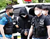 Dressed in a black hoodie with his face obscured by a mask and baseball cap, the suspect in the murder of a student at Inha University is escorted by police officers to his warrant review at Incheon District Court in Michuhol District, central Incheon on Sunday afternoon. [YONHAP]