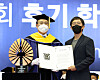 June Huh, right, a Korean-American mathematician and professor of mathematics at Princeton University who became the first person of Korean descent to receive the Fields Medal earlier this year, accepts the 'Proud Seoul National University Alumni' award from the university's president Oh Se-jung during the graduation ceremony held on the campus in Gwanak District, southern Seoul, on Monday. [YONHAP]