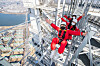 Customers take the Sky Bridge Tour at the Lotte World Tower in southern Seoul. The tour, which involves walking across a bridge 54 meters (177 feet) in the air, reopened after it was halted in the winter, Lotte Shopping said Thursday. [YONHAP]