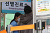 A health worker explains testing guidelines for Covid-19 at a testing center in Jung District, central Seoul, on Thursday. [YONHAP]