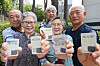 Vaccinated elderly people, sporting maskless faces, show their ID cards with inoculation stickers in Seoul on Monday, as the country began to issue the stickers to vaccinated people for mask-free activities. The vaccination certification is also available in a paper document or digitally on the COOV app. [YONHAP]