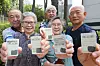 Vaccinated elderly people, sporting maskless faces, show their ID cards with inoculation stickers in Seoul on Monday, as the country began to issue the stickers to vaccinated people for mask-free activities. The vaccination certification is also available in a paper document or digitally on the COOV app. [YONHAP]