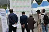 Older job seekers look through a recruiting board at a job fair in Busan in October. [SONG BONG-KEUN