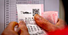 A person is checking their Lotto lottery ticket with the winning numbers. [YONHAP]