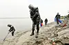 At an estuary of Imjin River in Gimpo, Gyeonggi, on Thursday, marines in protective gear search for land mines that may have washed downstream from North Korea by recent torrential rainfall and flooding. [YONHAP]