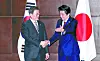 President Moon Jae-in and Japanese Prime Minister Shinzo Abe shake hands before a summit in Chengdu, China, on the sidelines of the 7th tripartite meeting among the three leaders on Dec. 24, 2019.