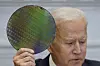 U.S. President Joe Biden holds up a silicon wafer as he participates virtually in the CEO Summit on Monday in Washington. [AP]