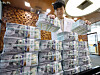 An official checks banknotes at a bank branch of Hana Bank in central Seoul on Friday. [NEWS1]