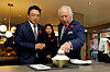 King Charles speaks with the owners of a Korean dessert shop in New Malden, England, and points at bingsoo, or Korean shaved ice, on Wednesday during his visit to the Korean community there. [REUTERS]