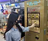 A woman uses a gold bar vending machine at a GS25 convenience store. GS Retail on Tuesday announced that it will be operating gold bar vending machines at five locations including GS convenience stores and its supermarket GS Fresh temporarily until August next year. [GS RETAIL]