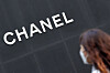 A passerby walks past a Chanel boutique. [NEWS1]