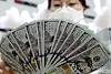 An official checks banknotes at a bank branch of Hana Bank in central Seoul, in this file photo taken March 4, 2020. [YONHAP]
