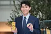 Tottenham Hotspur Son Heung-min holds up a commemorative coin and plaque issued by the Korea Minting and Security Printing Corporation (Komsco), at The Hyundai Seoul, Yeouido, on Monday . The commemorative coin, celebrating the 28-year-old's career so far, is available to purchase on the Komsco website. [YONHAP]