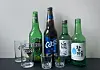 The two bottles of beer, left, and two bottles of soju pictured are some of the most commonly seen alcoholic drinks available at Korean restaurants. These restaurants usually give glasses branded with the name of the drinks. [LEE SUN-MIN]
