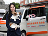 A model holds a dog in front of a Kia Ray, donated by 11st to the Korean Animal Welfare Association. 11st announced on Monday that the car was donated using the proceeds from a charity event sponsored by the e-commerce platform. The car will be used to transport animals from shelters to their families. [YONHAP]
