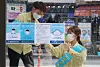 Gwangju officials tape fliers to a bus stop near Chonnam National University Tuesday informing the public about a new law on face masks. [YONHAP]