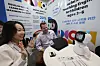 Participants in Edtech Korea Fair 2024 at Coex in southern Seoul demo an English-teaching robot for children on Monday. [YONHAP]