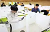 Teaching staffers at Samil Technical High School in Suwon, Gyeonggi, remove partitions that divide tables at the school's cafeteria on Monday, installed as a safety measure to prevent Covid-19, ahead of the new academic semester in March. Students will no longer be required to check their temperatures when arriving at school starting this semester. Korea's new Covid-19 cases hit the lowest figure in eight months on Monday, dropping to 4,026. The weekly average dropped by 15 percent every week over the past month, according to the Central Disaster and Safety Countermeasure Headquarters on Monday. [YONHAP]