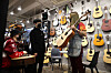 A store clerk shows a guitar to customers at an instrument shop in Seoul on Tuesday. According to Gmarket, an online market run by eBay Korea, guitar sales rose 44 percent between Dec. 25 and Jan. 24 as more people have been staying home due to the strict social distancing due to Covid-19. [YONHAP]