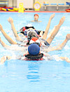 Elementary school teachers participate in a survival swim lesson at the Korea Coast Guard’s training pool in Busan on Thursday. The lesson was arranged by the Busan Metropolitan City Office of Education and the Coast Guard to improve the ability of teachers to teach swimming. [YONHAP]
