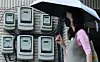 A pedestrian walks past electricity meters affixed to a wall in central Seoul. The Korea Electric Power Corporation on Wednesday announced its decision to freeze the electricity rate in the third quarter. [YONHAP]