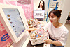 A model poses with a basket of Greek yogurt products in front of a self-checkout register at Greek Day’s first unmanned store, which opened in Gangnam District, southern Seoul, on Tuesday. Greek Day is the latest food company to adopt the growing self-checkout trend. [YONHAP]
