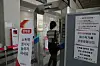 A visitor to EXCO, an exhibition convention center in Daegu, walks through an air curtain machine, which dispenses small particles of liquid sanitizer. [EXCO]
