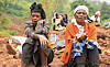 Zeritu Zekarias, 43, sits with her neighbor as her husband and relatives dig in search of the missing son at the site of a landslide of July 22 that buried people in the Gofa zone of southern Ethiopia on Monday. [REUTERS/YONHAP]