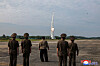 In this photo carried by North Korea's state-run Korean Central News Agency (KCNA), North Korean leader Kim Jong-un and officials look on as the Hwasongpho-11-Da-4.5, a new tactical ballistic missile, is test launched on Wednesday. [YONHAP]