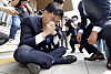 Democratic Party Rep. Jang Kyung-tae is on the ground after he collapsed while reading a written statement to oppose the government's push for separating TV license fees from electricity bills in front of the Korea Communications Commission headquarters in Gwacheon, Gyeonggi, on Wednesday. [NEWS1]