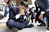 Democratic Party Rep. Jang Kyung-tae is on the ground after he collapsed while reading a written statement to oppose the government's push for separating TV license fees from electricity bills in front of the Korea Communications Commission headquarters in Gwacheon, Gyeonggi, on Wednesday. [NEWS1]