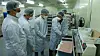 An engineer from Samsung Electronics instructs workers at a local facial mask manufacturer on how to improve production capacity. [YONHAP]