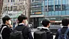 Students wait to cross the street towards a building of private academies, or hagwon, in Daechi-dong of Gangnam District, southern Seoul, on March 4, 2021. [YONHAP]