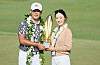 Kim Si-woo of Korea poses with his wife Oh Ji-hyun and the trophy after putting in to win on the 18th green during the final round of the Sony Open in Hawaii at Waialae Country Club in Honolulu, Hawaii on Sunday.  [GETTY IMAGES]