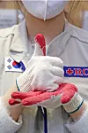A Red Cross volunteer in Suwon, Gyeonggi, signs the Korean sign language word for ’respect“ or ’pride“ on April 28, 100 days after Korea’s first Covid-19 case.[NEWS1]